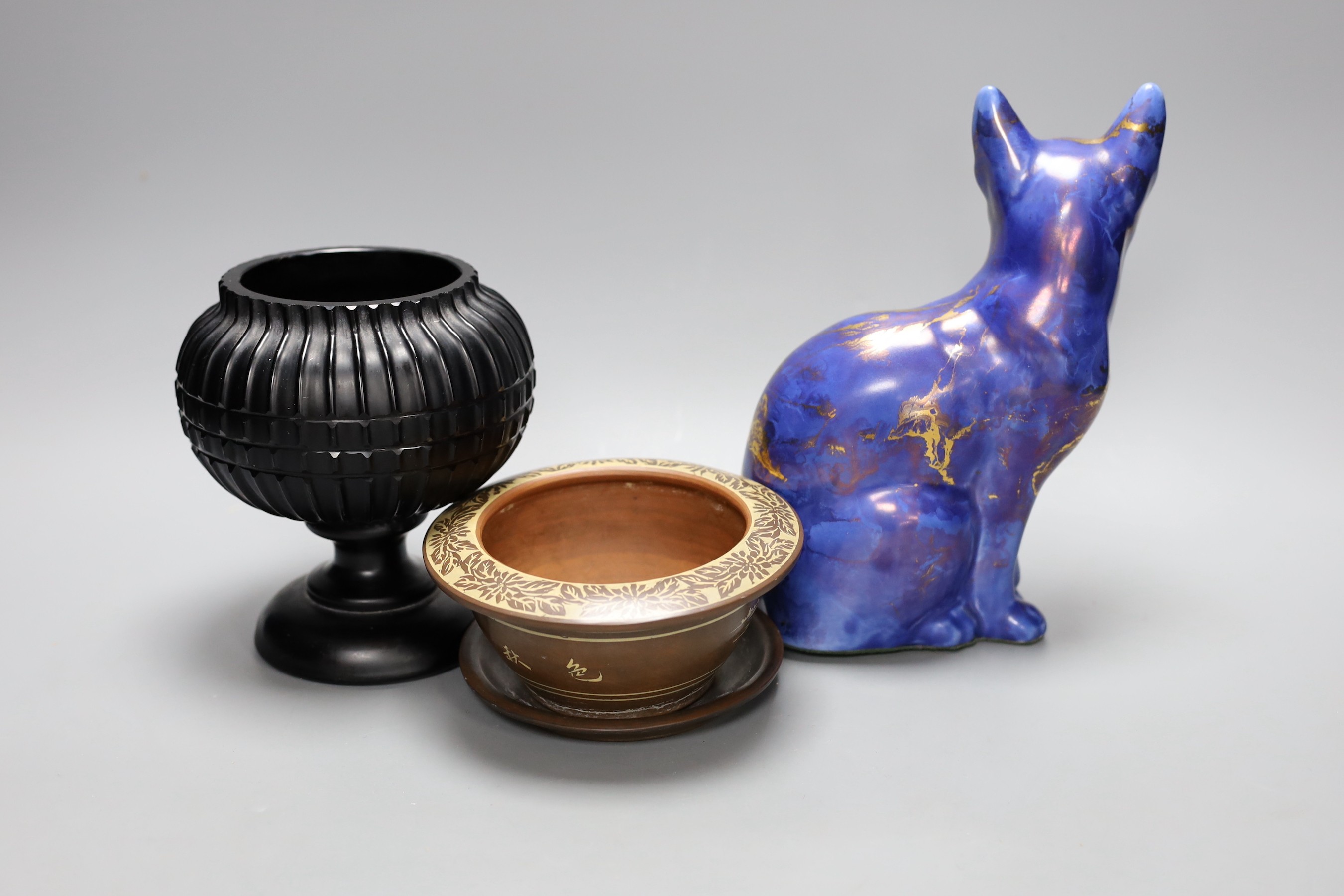 An opaque black glass vase, a Chinese bowl on stand and a Tony Laverick cat model, 22cm tall